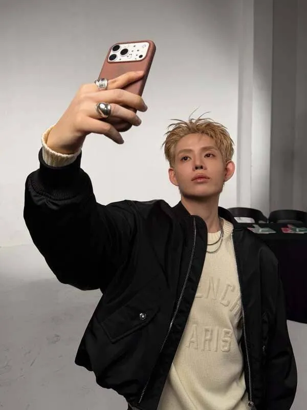 anh-dillan-selfie-3 Ảnh Dillan selfie giơ cao điện thoại với áo bomber đen hậu trường