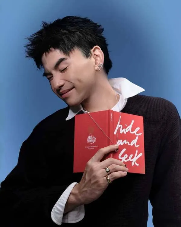 anh-the-thien-hinh-nen-doc-3 Hình ảnh Thể Thiên ôm cuốn sổ đỏ, cúi mặt cười nhẹ trên nền xanh