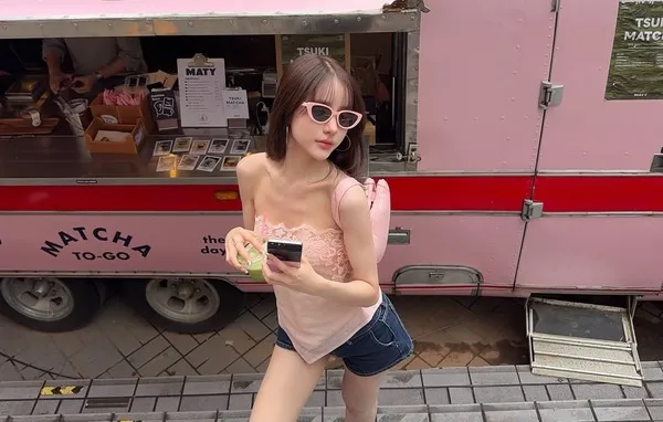 Yoshi Rinrada Thurapan đeo kính bên cửa hàng